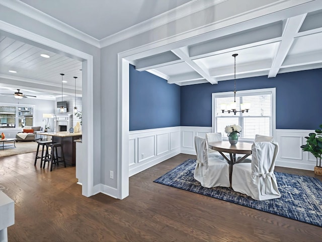 dining space with ceiling fan with notable chandelier, beamed ceiling, plenty of natural light, and dark wood finished floors