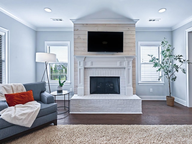 living room featuring ornamental molding, a healthy amount of sunlight, and visible vents