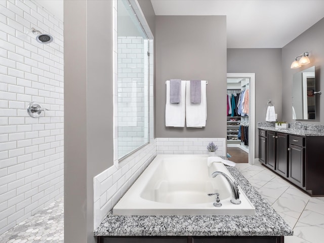 bathroom with a walk in closet, marble finish floor, a walk in shower, and vanity