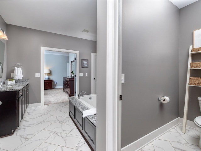 bathroom featuring marble finish floor, a garden tub, toilet, and baseboards