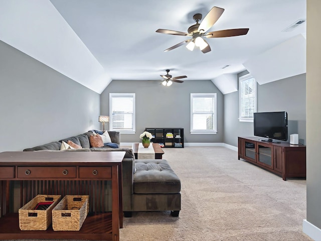 living room with carpet floors, visible vents, a wealth of natural light, and lofted ceiling