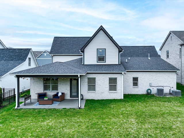 back of house featuring a patio, central AC unit, brick siding, roof with shingles, and a lawn