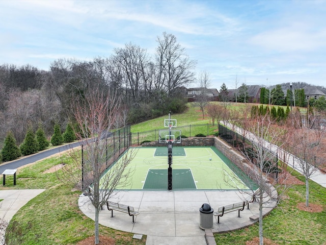 exterior space featuring a lawn, fence, and basketball court