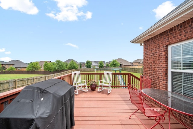 deck with area for grilling, a fenced backyard, and a residential view