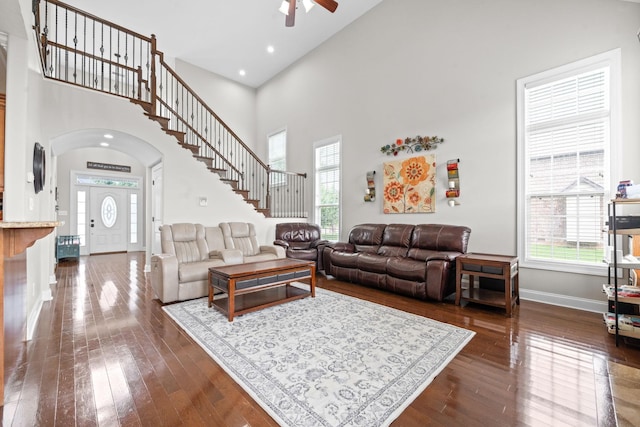 living room featuring stairway, plenty of natural light, baseboards, and dark wood-style flooring