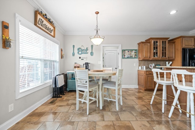 dining room with ornamental molding and baseboards