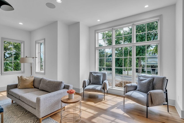 living area with baseboards, wood finished floors, and recessed lighting