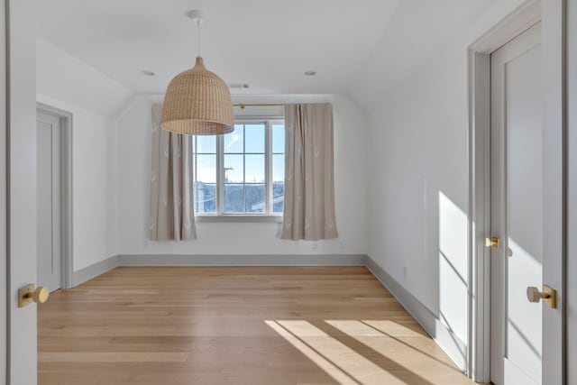 bonus room featuring light wood-style floors, baseboards, visible vents, and vaulted ceiling