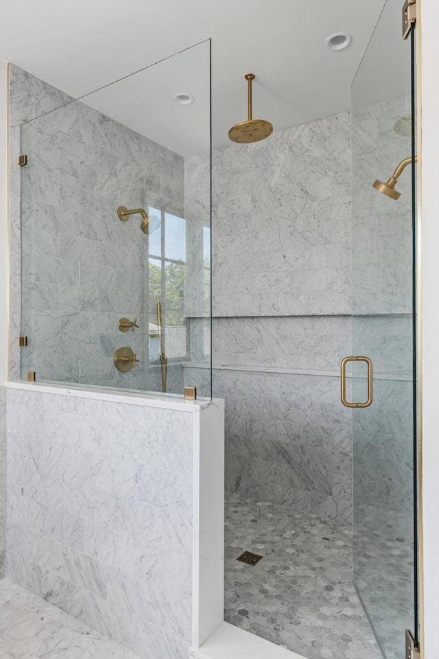 bathroom featuring a marble finish shower