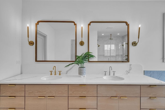 bathroom featuring double vanity, a stall shower, and a sink