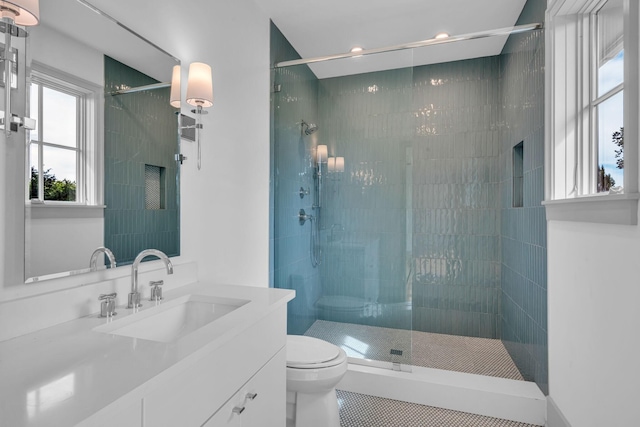 full bath featuring tiled shower, vanity, and toilet