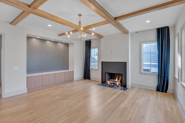 unfurnished living room with light wood-style flooring, coffered ceiling, beam ceiling, and a fireplace with flush hearth