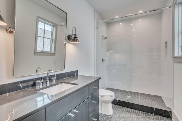 full bathroom with toilet, tile patterned floors, a tile shower, and vanity