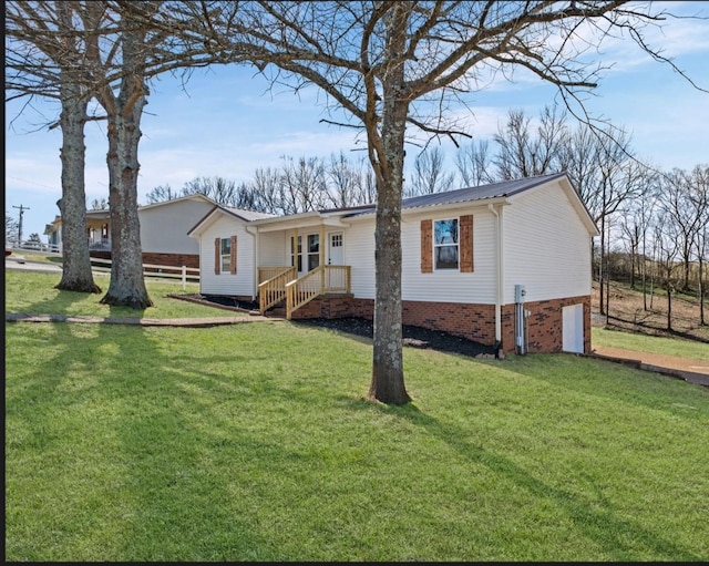 ranch-style house featuring an attached garage, metal roof, fence, and a front lawn