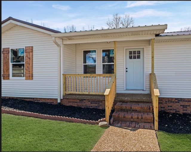 view of exterior entry featuring covered porch