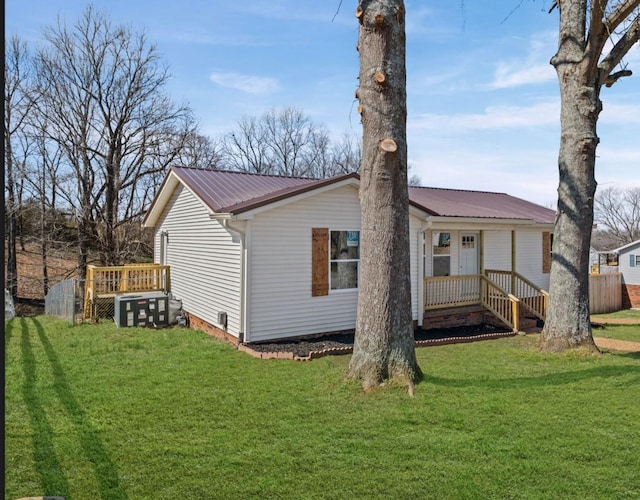 rear view of property with metal roof and a yard