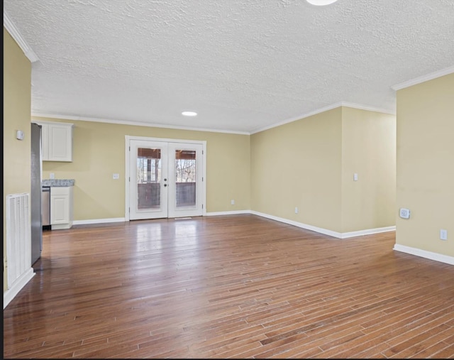 unfurnished living room featuring a textured ceiling, wood finished floors, baseboards, french doors, and crown molding