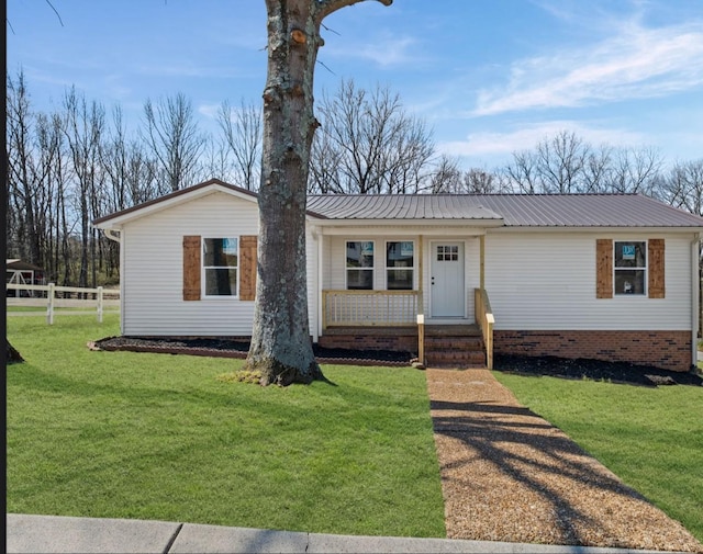 view of front of house with metal roof, a front lawn, a porch, and fence