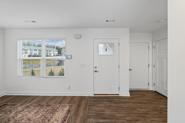 entryway with dark wood-type flooring, visible vents, and baseboards