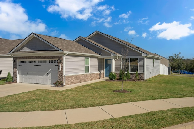 craftsman-style home featuring a garage, stone siding, concrete driveway, and a front yard