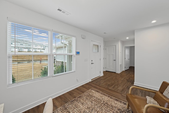 foyer entrance with baseboards, visible vents, wood finished floors, and recessed lighting