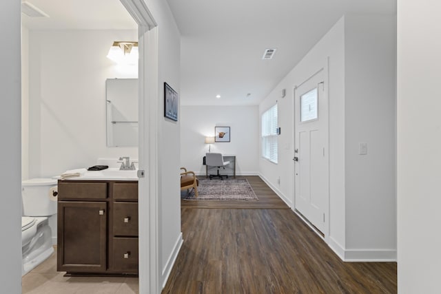 entrance foyer featuring visible vents, baseboards, and wood finished floors