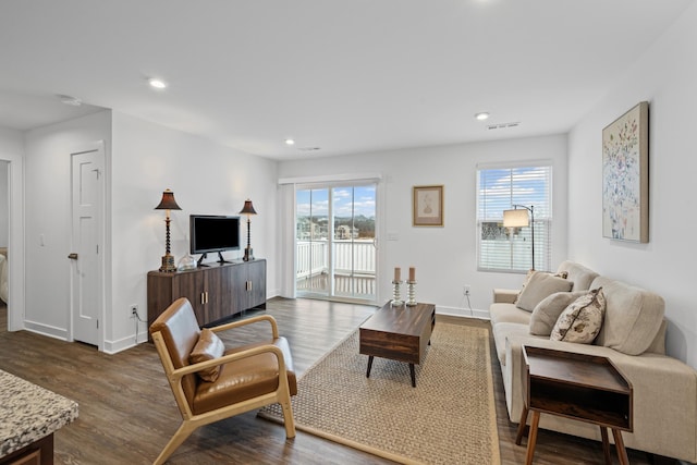 living area featuring baseboards, dark wood finished floors, visible vents, and recessed lighting