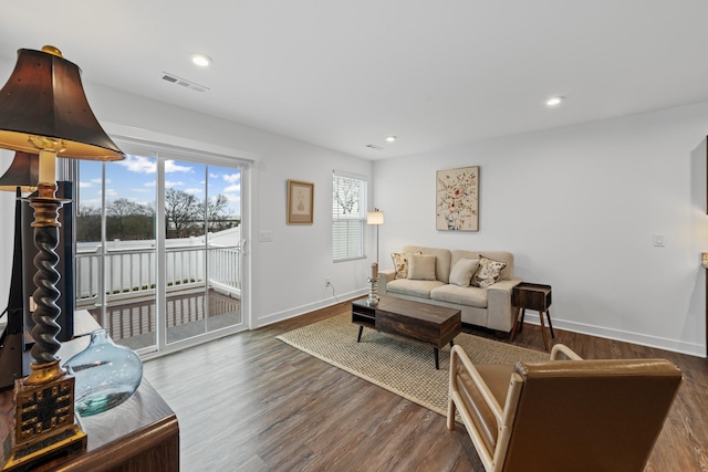 living area featuring recessed lighting, visible vents, baseboards, and wood finished floors