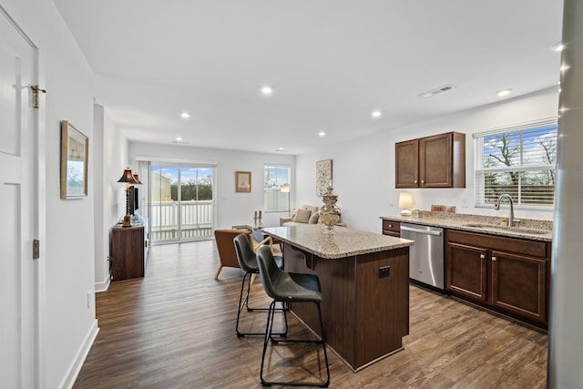 kitchen featuring a center island, dark wood-style flooring, dishwasher, and a sink