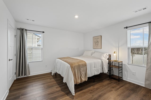 bedroom with multiple windows, visible vents, and wood finished floors