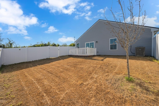 view of yard with a deck, a fenced backyard, and central air condition unit