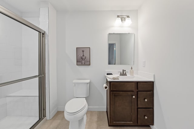 bathroom featuring a stall shower, baseboards, toilet, tile patterned floors, and vanity