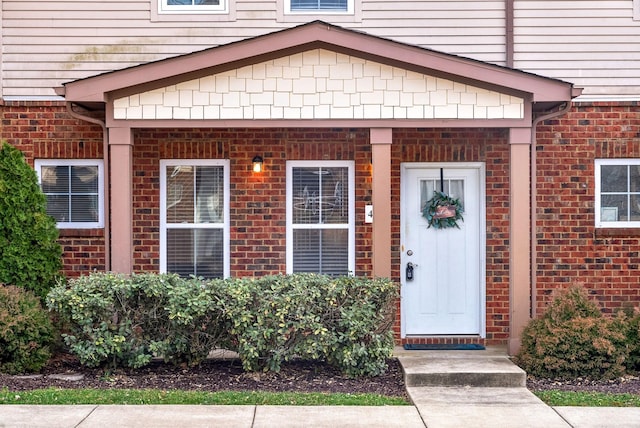 view of exterior entry with brick siding