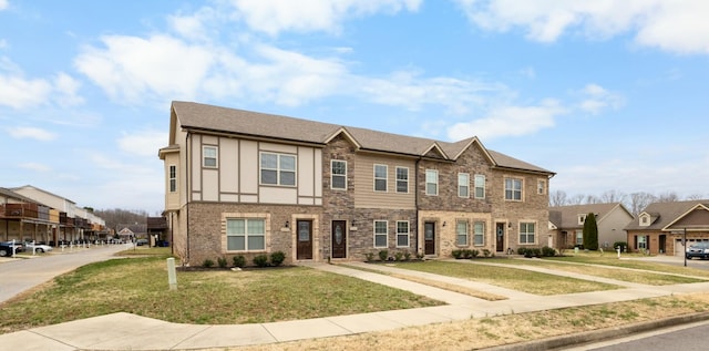 townhome / multi-family property featuring stucco siding, a residential view, and a front yard