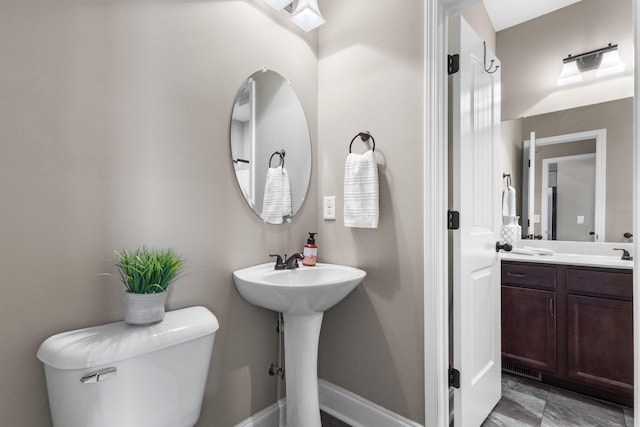 bathroom featuring baseboards and toilet