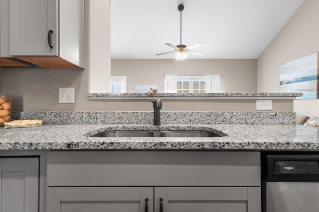 interior space featuring a ceiling fan, a sink, light stone countertops, gray cabinetry, and stainless steel dishwasher