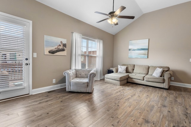 living room featuring lofted ceiling, wood finished floors, visible vents, a ceiling fan, and baseboards