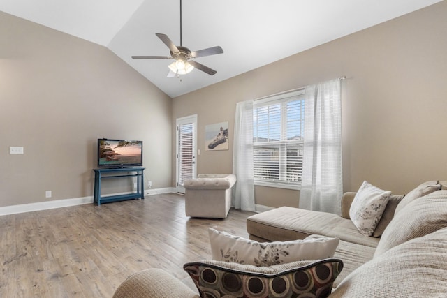 living room featuring vaulted ceiling, light wood-style flooring, baseboards, and ceiling fan