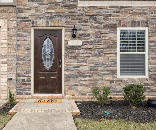 property entrance featuring stone siding and brick siding