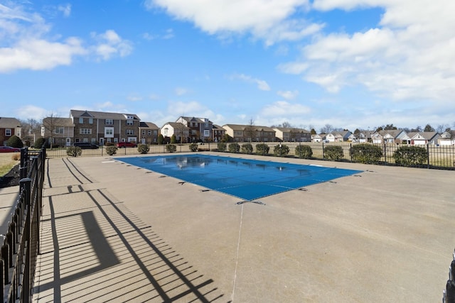 pool featuring a residential view, a patio area, and fence