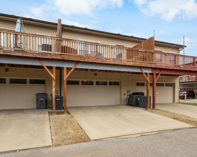 view of front of property with an attached garage, cooling unit, and concrete driveway