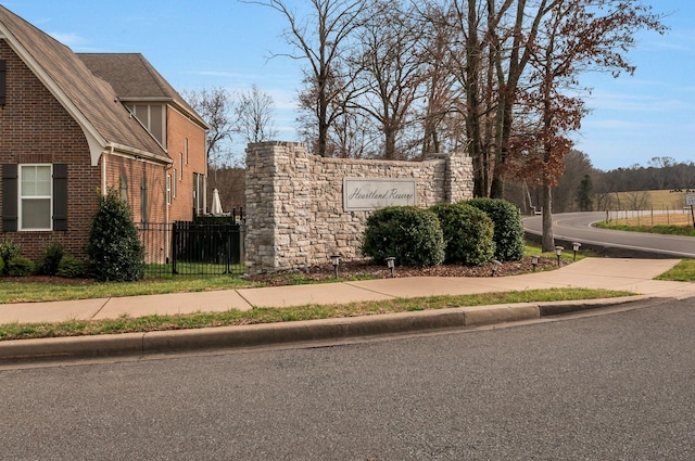 community / neighborhood sign featuring fence