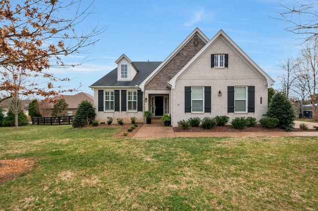 traditional home featuring a front yard, fence, and brick siding