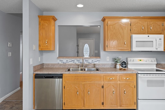 kitchen with white appliances, tasteful backsplash, light countertops, and a sink