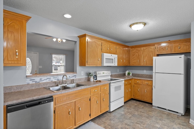 kitchen featuring white appliances, a sink, a ceiling fan, light countertops, and decorative backsplash