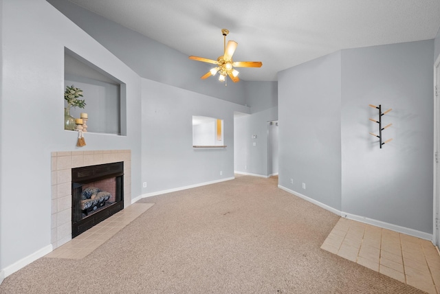 unfurnished living room with carpet, a tile fireplace, a ceiling fan, and baseboards