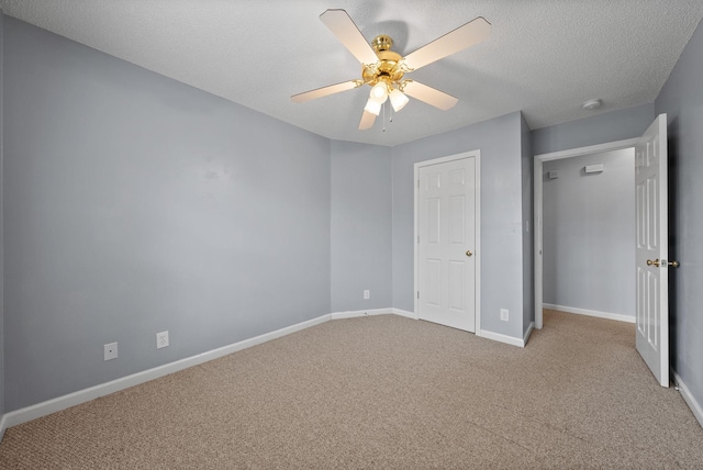 unfurnished bedroom with a ceiling fan, a textured ceiling, baseboards, and carpet flooring