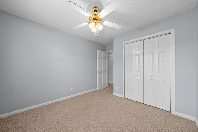 unfurnished bedroom featuring carpet floors, a closet, ceiling fan, and baseboards