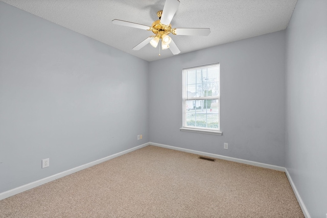 empty room with visible vents, baseboards, ceiling fan, a textured ceiling, and carpet floors