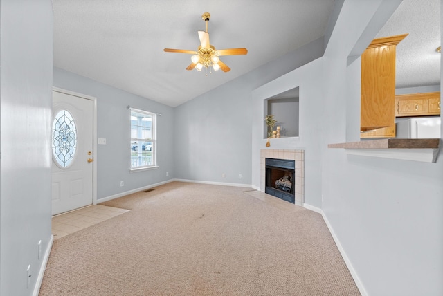 unfurnished living room featuring lofted ceiling, a fireplace, baseboards, and carpet flooring